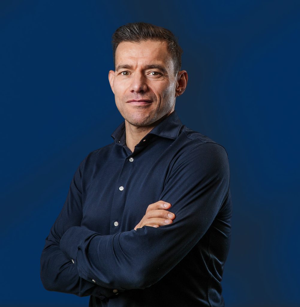 Man met donkerblauw overhemd tegen blauwe achtergrond