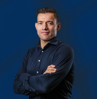 Man met donkerblauw overhemd tegen blauwe achtergrond